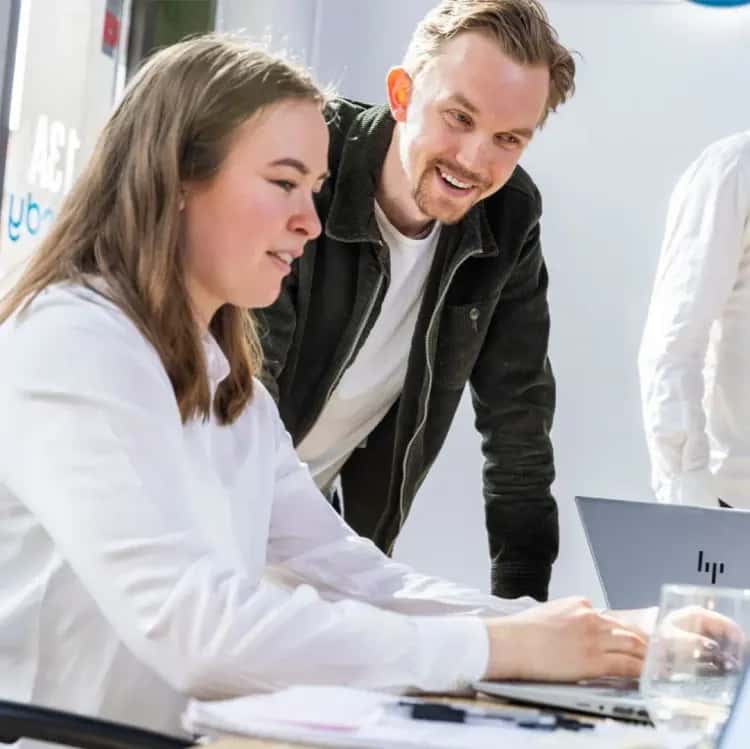 A female developer talks to her colleague about a problem on the computer